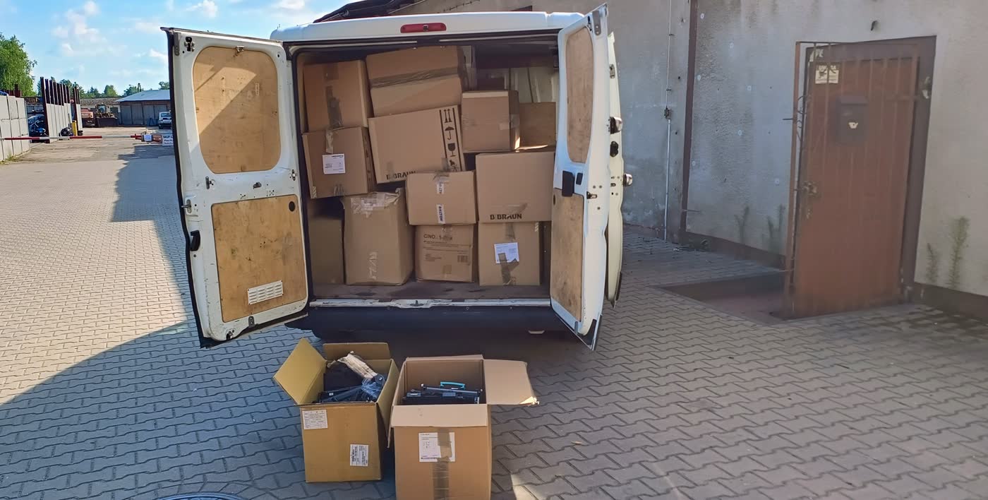 Wnętrze samochodu wypełnione kartonami po odbiorze u klientów